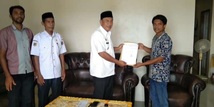 Harianto Galib S.sos Camat simpang raya menyerahkan Surat PLT kepala desa Dwipa karya .(Dok.Kilasbanggai.com)